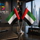 Two small UAE flags on a stand with a desk setup featuring 'Graphic Jet' branding.